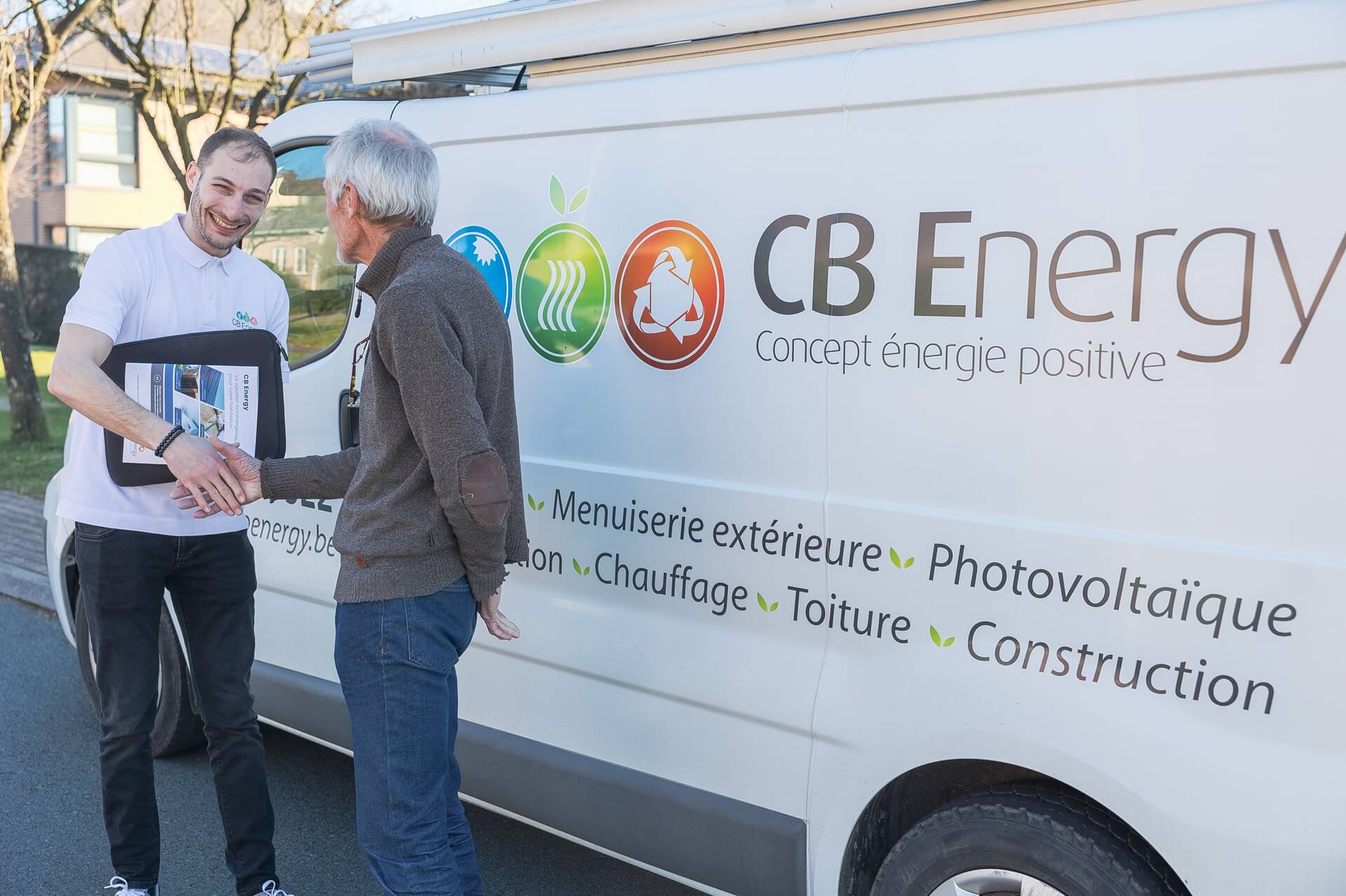 Employé de CB Energy serrant la main d'un client devant la camionnette